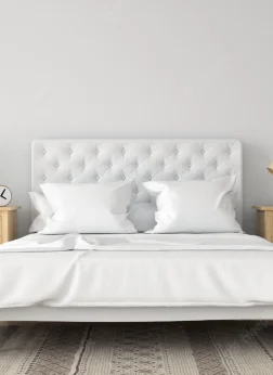 A high-end white bed with an array of comfortable and stylish pillows